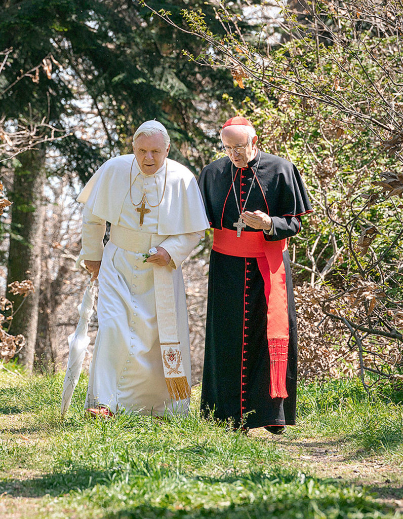 Anthony Hopkins (left) plays Pope Benedict and Jonathan Pryce is Pope Francis in “The Two Popes,” debuting Dec. 13 in theaters, and streaming on Netflix after that. (Netflix)
