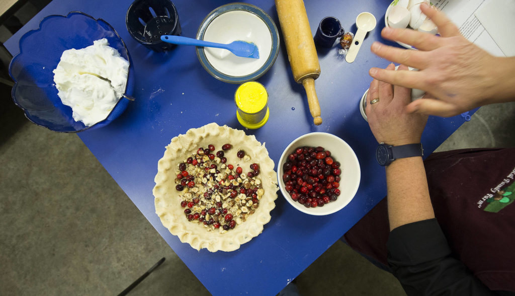Karen Fuentes chops hazelnuts to add to a cranberry pie during a cooking demonstration at her farm near Silvana. (Andy Bronson / The Herald)
