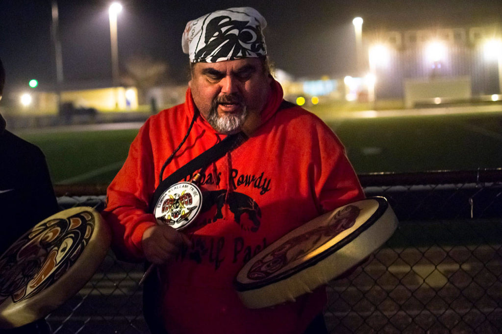 Mark Charles of the Lower Elwha Klallam Tribe leads a song during the vigil for Tristen Pisani at Spartan Stadium in Forks on Thursday. (Jesse Major / Peninsula Daily News)
