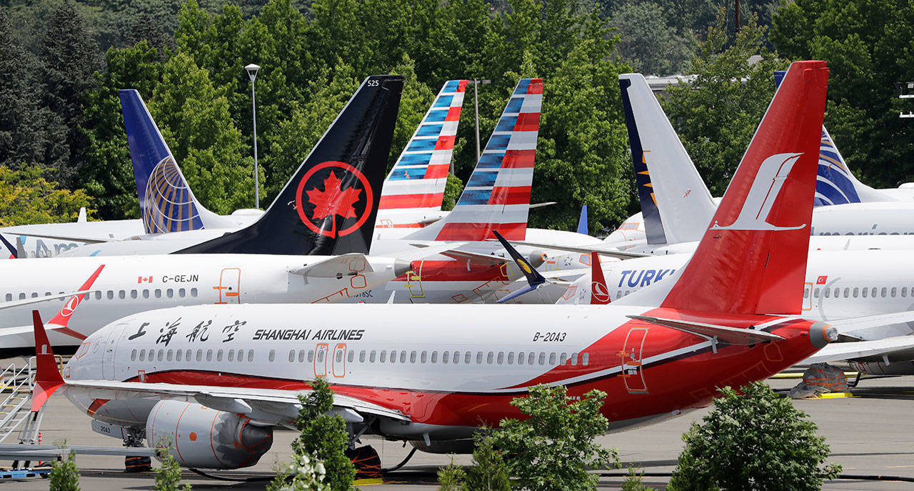 In this June 27 photo, dozens of grounded Boeing 737 Max airplanes crowd a parking area adjacent to Boeing Field in Seattle. Safety regulators want to fine Boeing nearly $4 million, saying that the company installed critical wing parts on 133 planes even though it knew the parts were faulty. (AP Photo/Elaine Thompson, File)