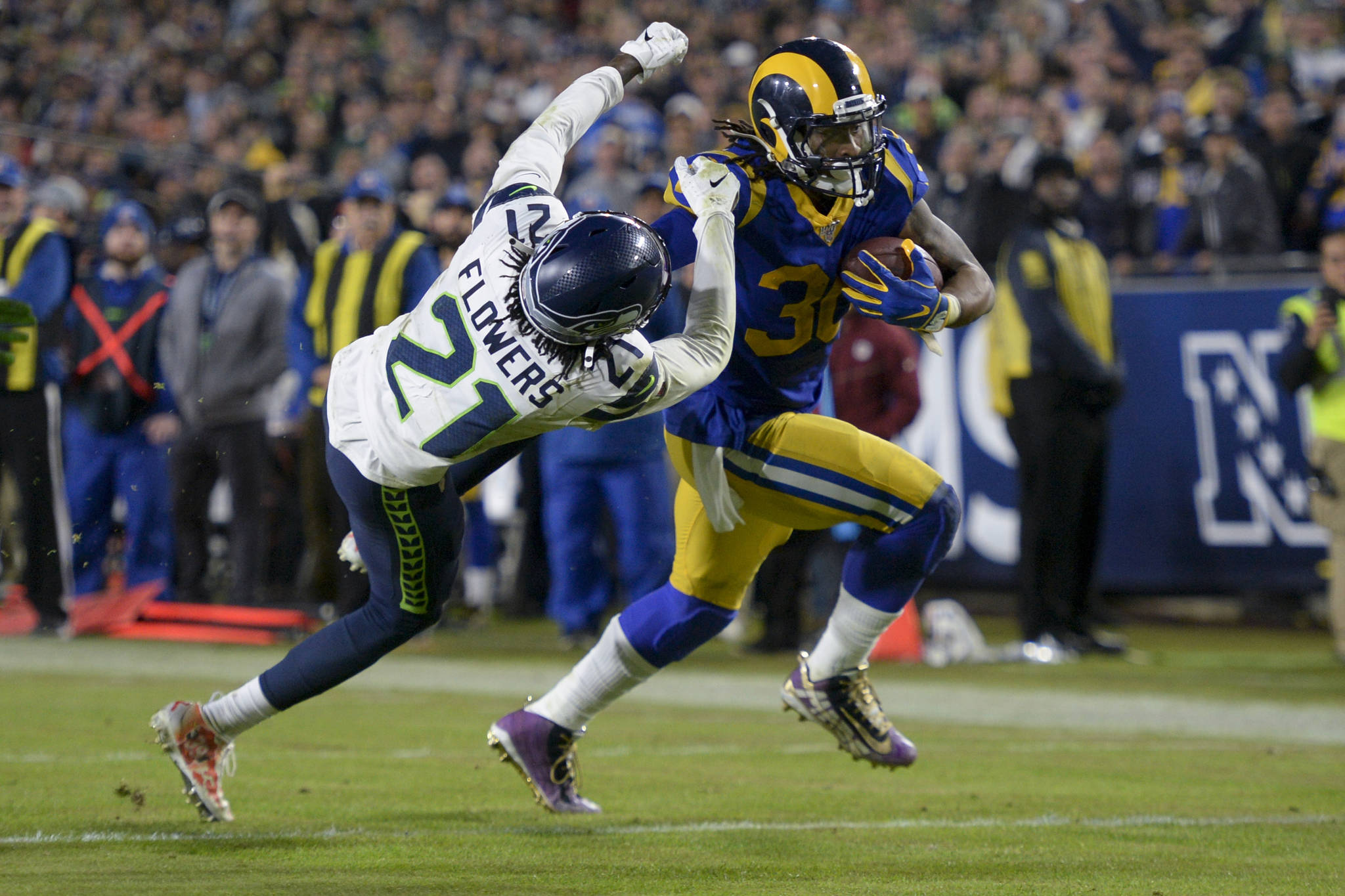Los Angeles Rams running back Todd Gurley stiff arms Seahawks cornerback Tre Flowers as he runs for a touchdown in the second half of Sunday night’s game in Los Angeles. (Kyusung Gong / Associated Press)