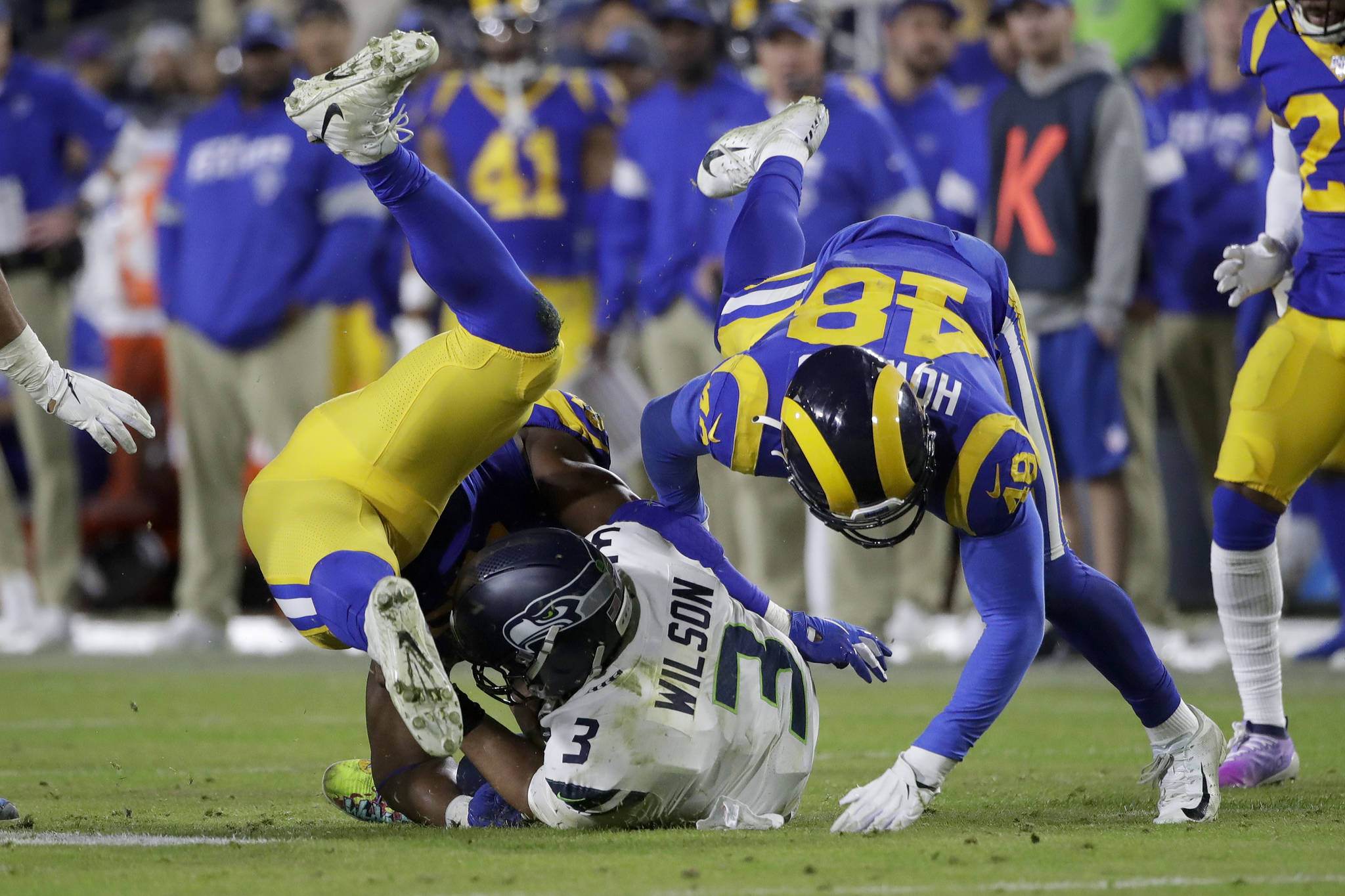 Marcio Jose Sanchez / Associated Press                                Seattle Seahawks quarterback Russell Wilson (3) is tackled by Los Angeles Rams linebackers Obo Okoronkwo (left) and Travin Howard during the second half Sunday’s game in Los Angeles.