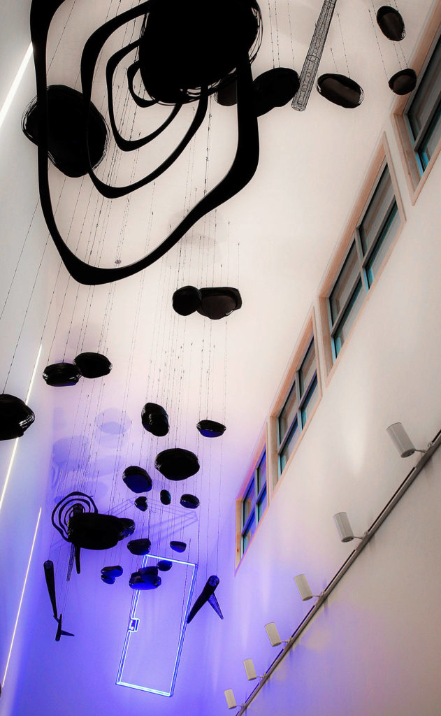 At the new Evergreen Branch of the Everett Public Library is a large artwork called “Growth, Search, Escape” by Christine Clark of Portland, Oregon. The third segment, “Escape,” has stepping stones leading to a blue lighted doorway. Raised ceilings provide a unique space for suspended sculpture and light. (Dan Bates / The Herald)
