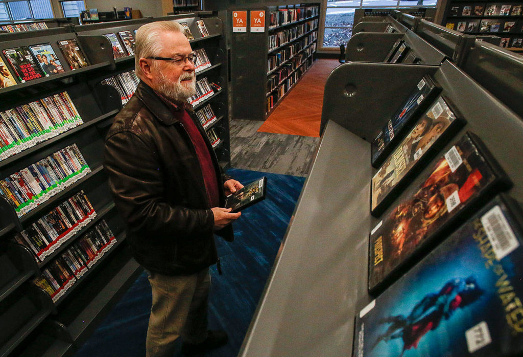 Phil Mitchell and his wife Jeanne had hoped to attend the Evergreen Branch of the library grand opening Friday, but decided to come back Monday and enjoy it with a smaller crowd. (Dan Bates / The Herald)
