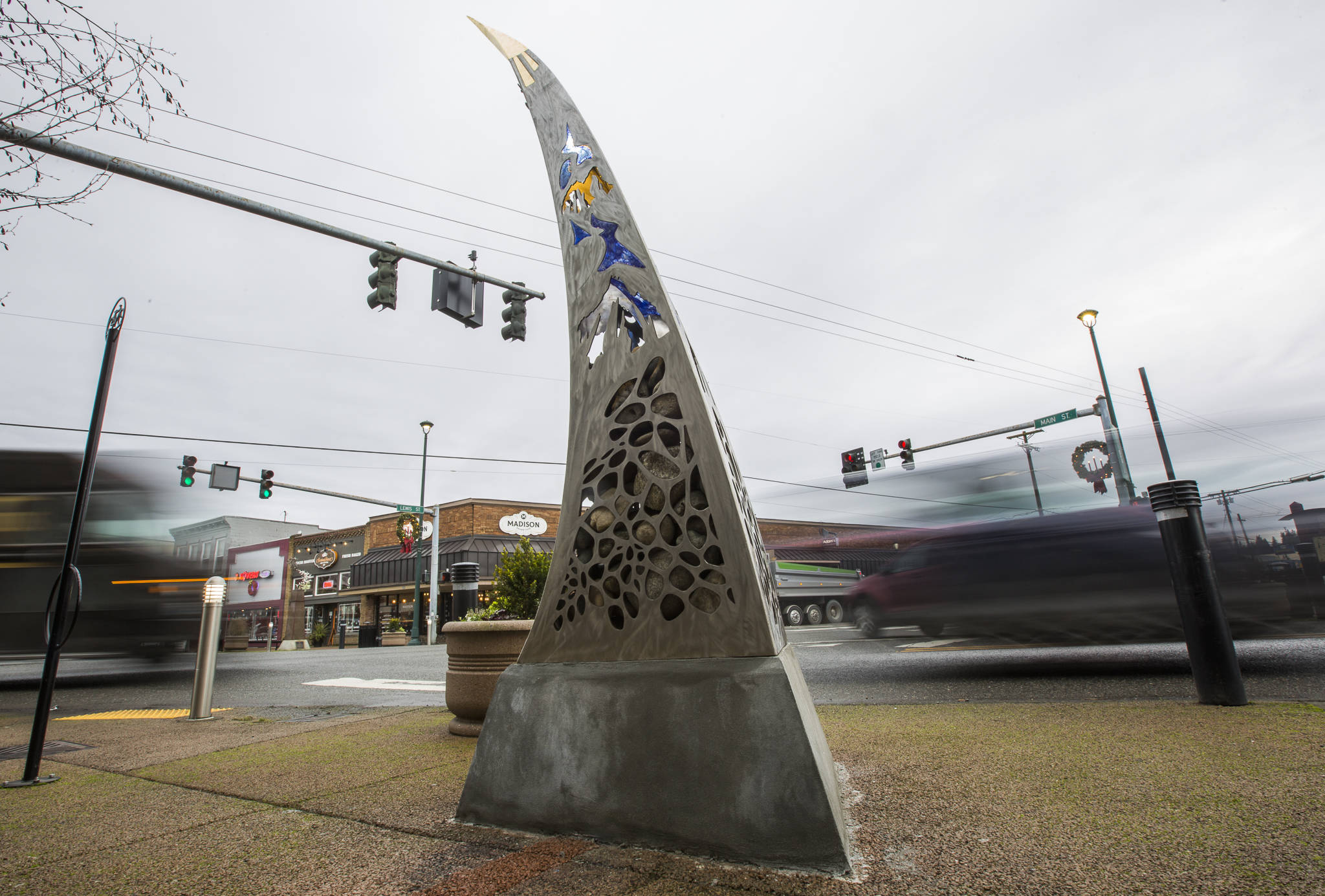 Cars drive by the new “Guardians of the Mountain Pass” sculpture by Milo White and Jay Bowen on the southeast corner of Main and Lewis streets. The sculpture was commissioned by the city of Monroe. (Olivia Vanni / The Herald)