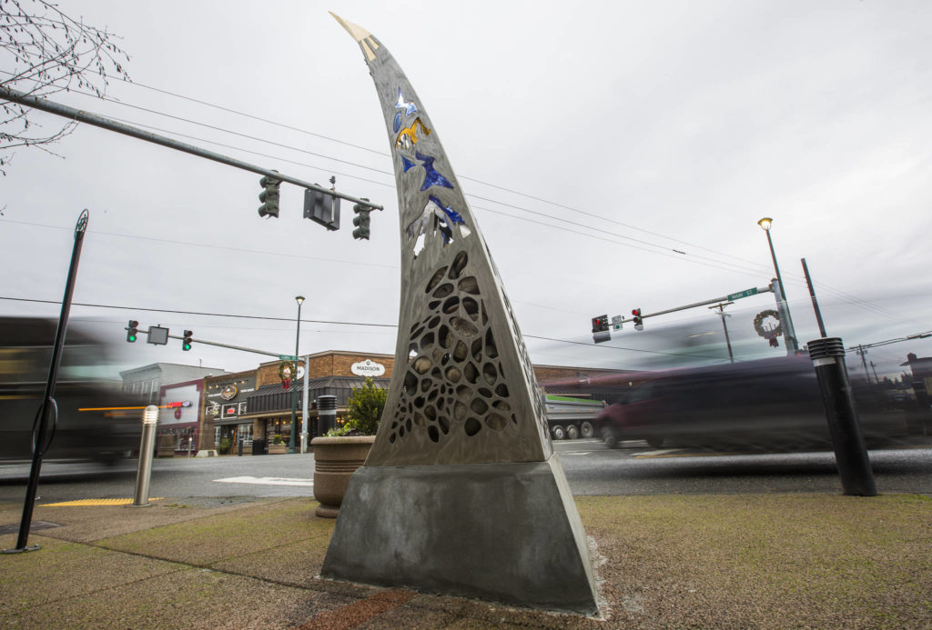 Cars drive by the “Guardians of the Mountain Pass” sculpture by Sedro-Woolley sculptor Milo White on the southeast corner of Main Street and Lewis Street on Wednesday, Dec. 11, 2019 in Monroe, Wash. The sculpture was commissioned by the City of Monroe. (Olivia Vanni / The Herald)
