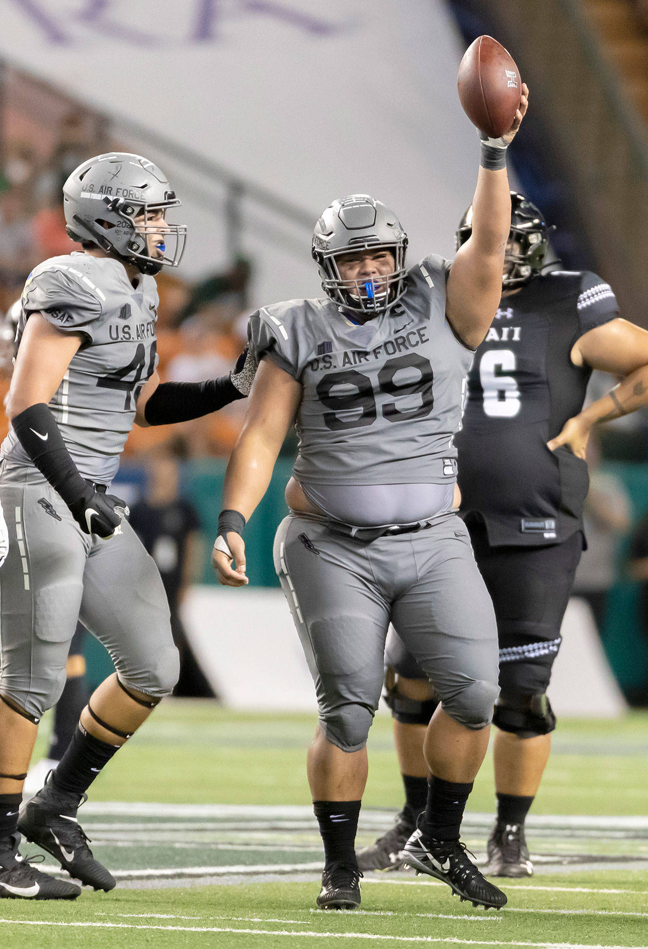 Air Force’s Mosese Fifita (99) holds up the football in celebration of recovering a fumble during an Oct. 19 win at Hawaii in Honolulu. Fifita, a two-sport standout at Snohomish’s Glacier Peak High School, will lead the Falcons against Washington State in the Cheez-It Bowl on Dec. 27 in Phoenix. (AP Photo/Eugene Tanner)