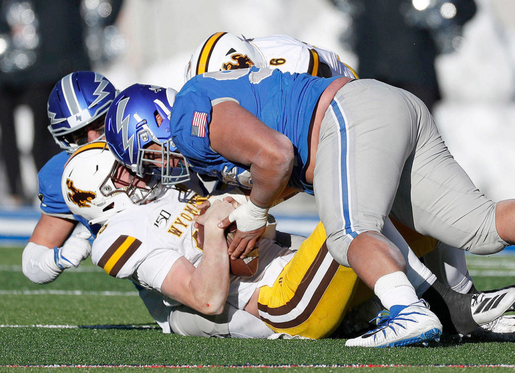 Air Force defensive lineman Mosese Fifita (top) sacks Wyoming quarterback Levi Williams during the Falcons’ 20-6 win over the Cowboys on Nov. 30 in Colorado Springs. (AP Photo/David Zalubowski)
