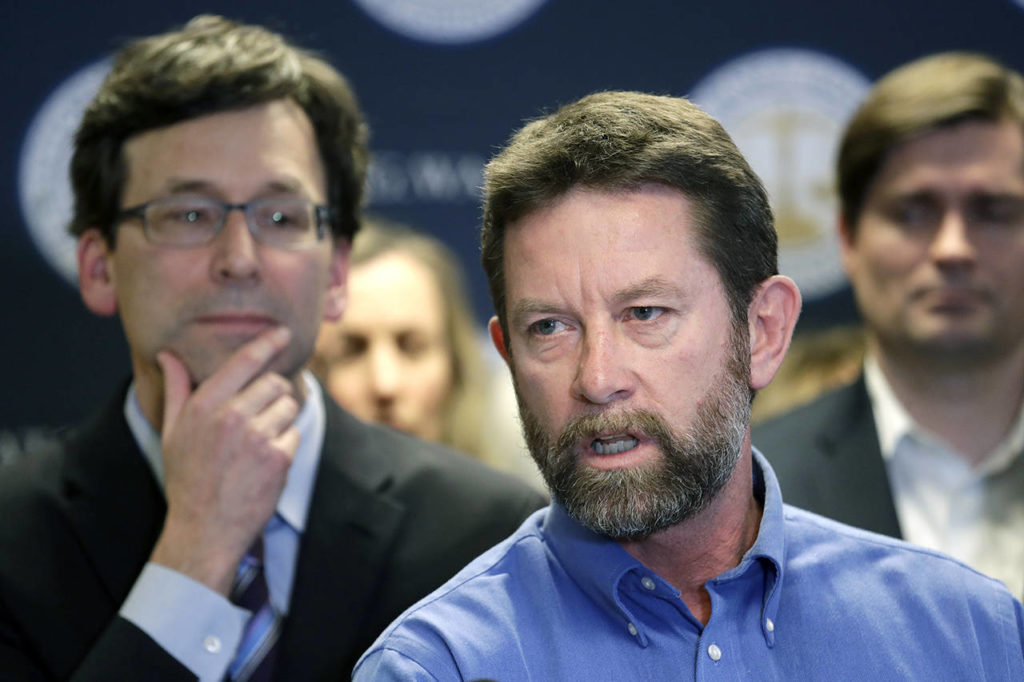 Washington state Attorney General Bob Ferguson (left) looks on as Paul Kramer, the father of a teenage son who survived a mass shooting in Mukilteo, speaks at a news conference announcing legislation to combat mass shootings in the state, Thursday in Seattle. (AP Photo/Elaine Thompson)
