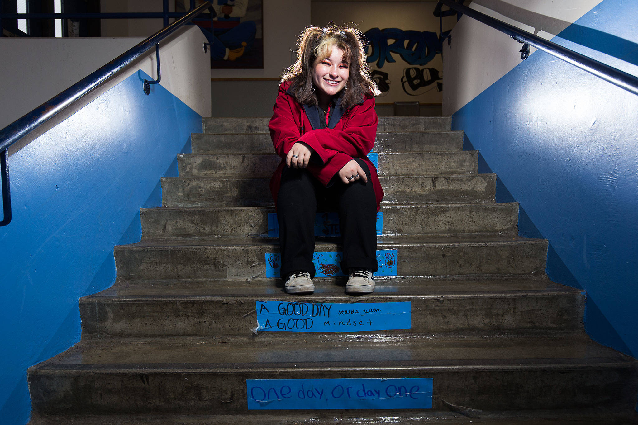 Sultan High Senior Jasmine Romero sits on stairs bearing positive messages at the school. (Andy Bronson / The Herald)