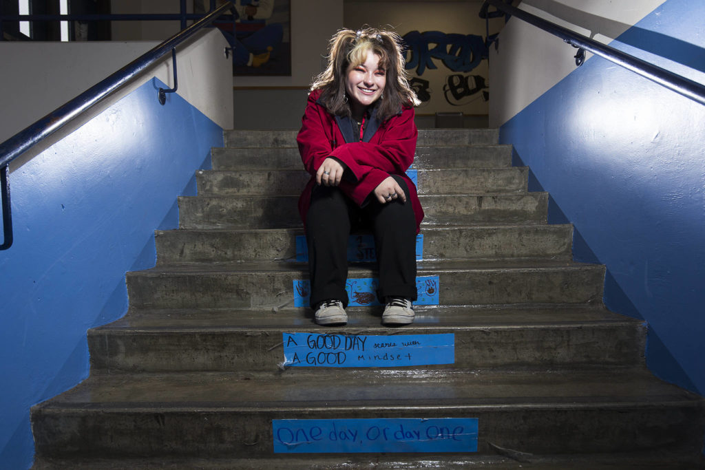 Sultan High Senior Jasmine Romero sits on stairs bearing positive messages at the school. (Andy Bronson / The Herald)
