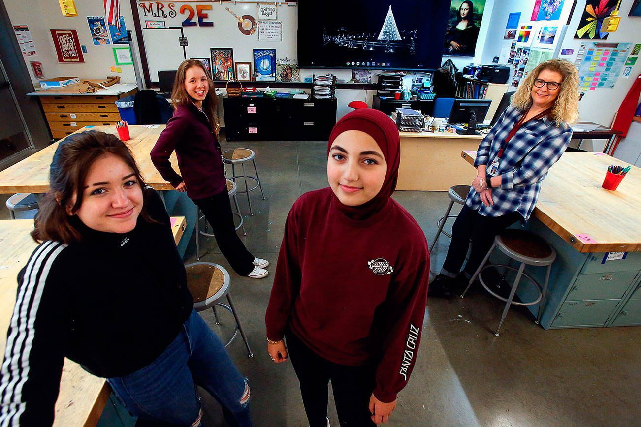 Art students at Cavelero Mid High School, Ivonne Salazar, 15 (left) and Maryam Hasan, 14 (center) join teachers Karen Towey (back right) and Kylen Fountain to talk about creating ornaments for the National Christmas Tree project. An image of the tree, located near the White House, is displayed on a screen in the classroom. (Dan Bates) / The Herald)