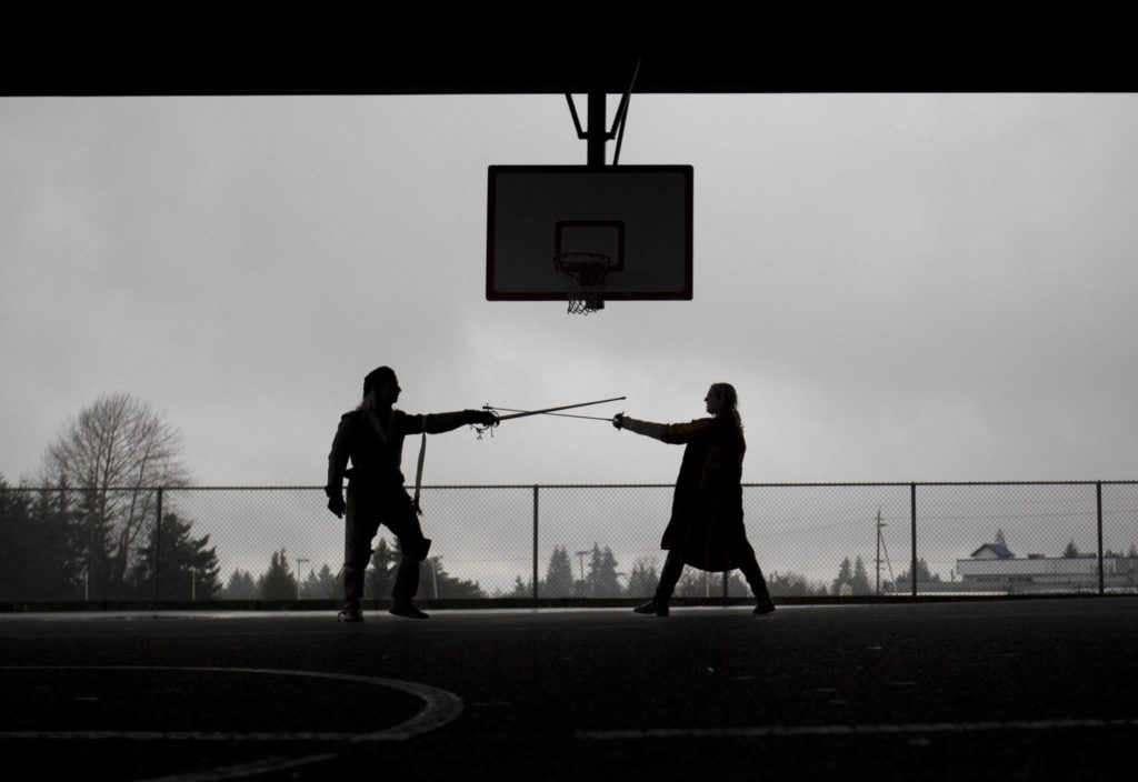 Stephen Henning (left), whose LARP persona is Conal McLaren, works on fencing techniques with Bethaney Dukellis, whose persona, Halawa Al-Waddi, is Concal McLaren’s cadet, during practice at Evergreen Middle School in Everett. (Olivia Vanni / The Herald)
