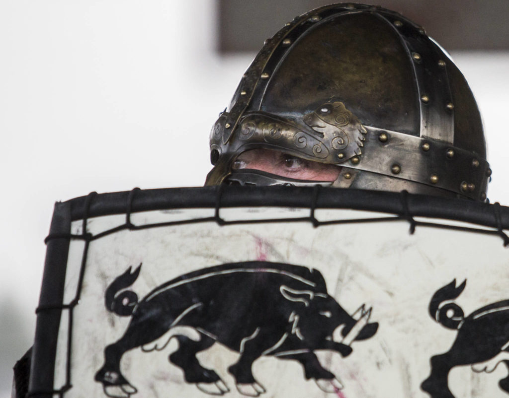Timm Rulison, whose persona is Sir Timothy AP Caradoc, peers over the top of his shield during combat practice battle at Evergreen Middle School in Everett. (Olivia Vanni / The Herald)
