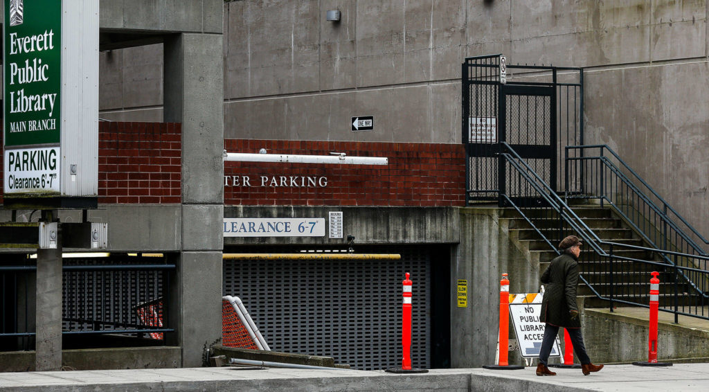 A pedestrian walks past the west entrance to the Everett Public Library parking garage Wednesday. (Dan Bates / The Herald)
