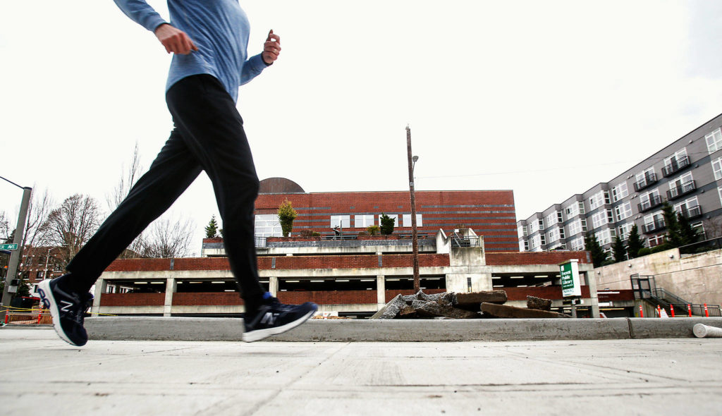 Across from the Everett Public Library, a jogger runs south along a restyled section of Rucker Avenue this week. The Rucker Renewal project is intended to make the area more pedestrian-friendly, with wide sidewalks and other features. (Dan Bates / The Herald)
