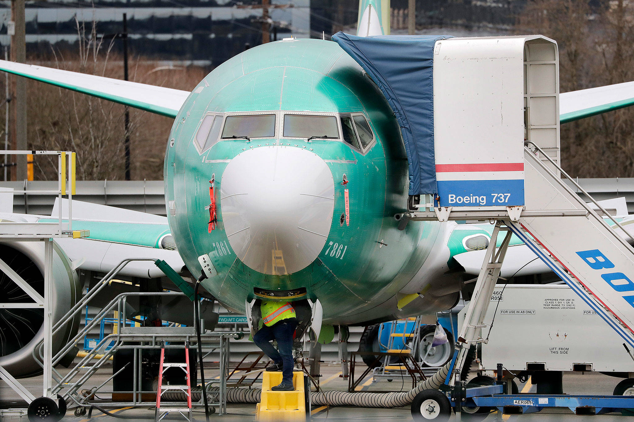 A worker and a Boeing 737 Max jet Monday in Renton. (AP Photo/Elaine Thompson)