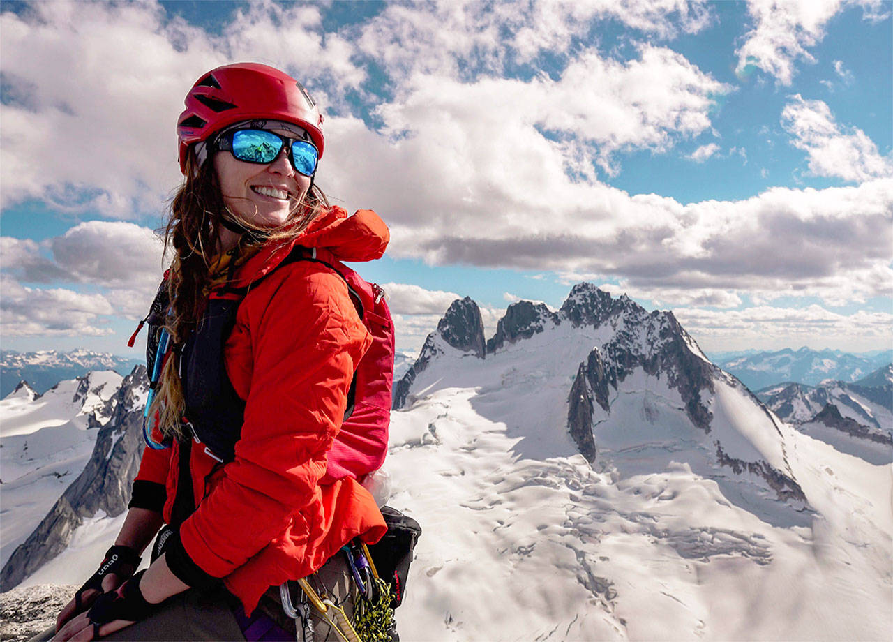 Snohomish native Taryn Simpson admires the view from the summit of Bugaboo Spire in eastern British Columbia. Dealing with rheumatoid arthritis has not prevented her from climbing some of the tallest peaks in the Northwest. (Photo provided by Taryn Simpson)