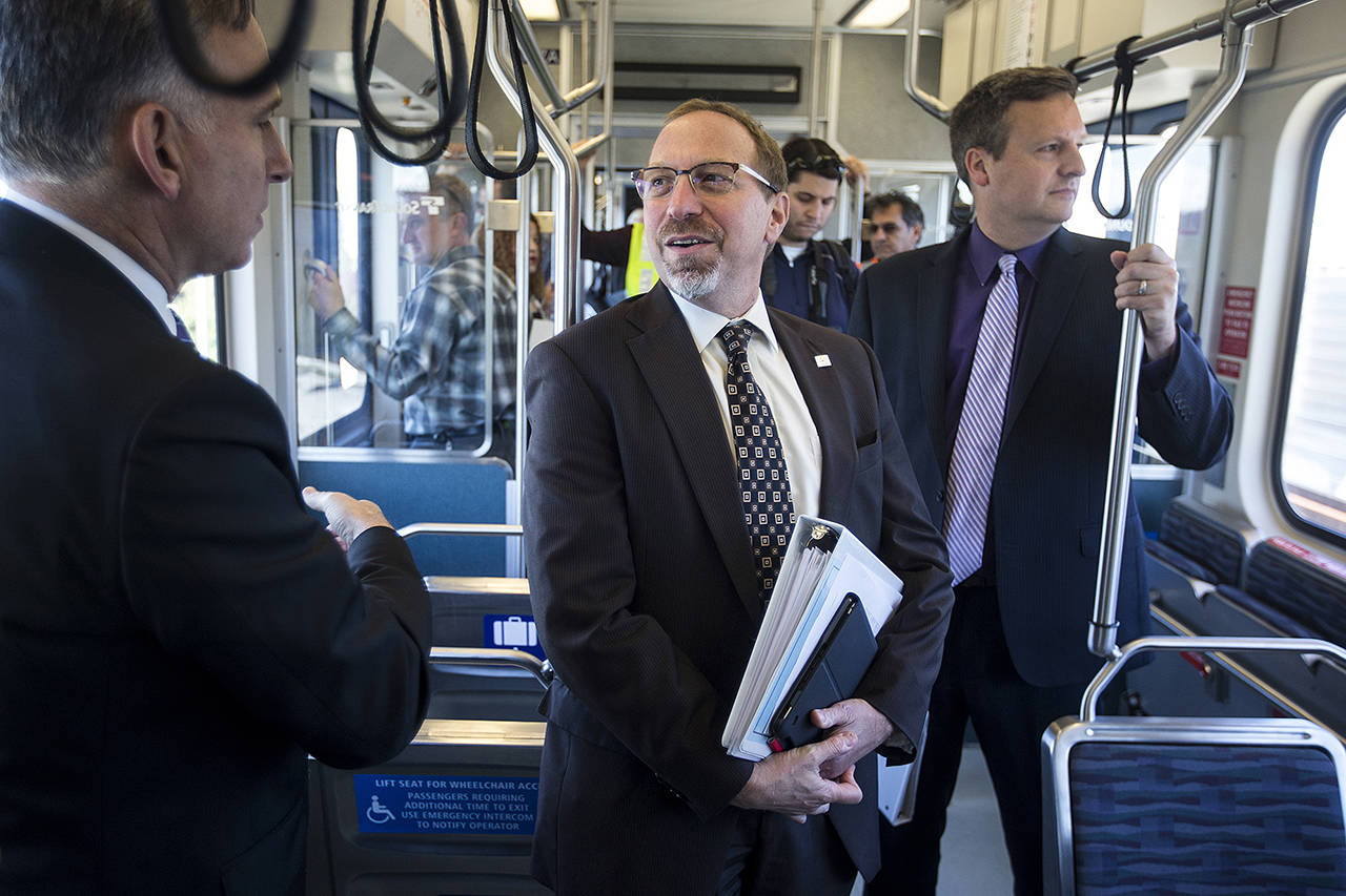 Sound Transit CEO Peter Rogoff (center) takes a ride on light rail from the Angle Lake Station in Seatac with King County Executive Dow Constantine (left) on Sept. 21, 2016. (Ian Terry / Herald file)