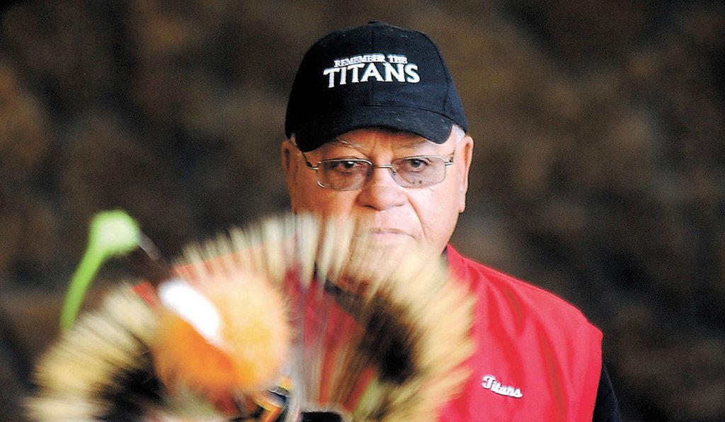 Herman Boone, the coach featured in the movie “Remember the Titans,” peers over the headdress of a Shoshone-Bannock dancer to speak to a large crowd in Pocatello, Idaho, in 2005. Boone died Wednesday at 84. (Joshua Duplechian/The Idaho State Journal file)
