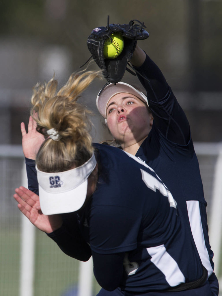 With bases loaded and two outs, Glacier Peak’s Ashley Schmer makes the inning-ending catch over the head of teammate Phoebe Schultz as Glacier Peak beat Lake Stevens 6-3 in a fastpitch game on April 9 in Lake Stevens. (Andy Bronson / The Herald)