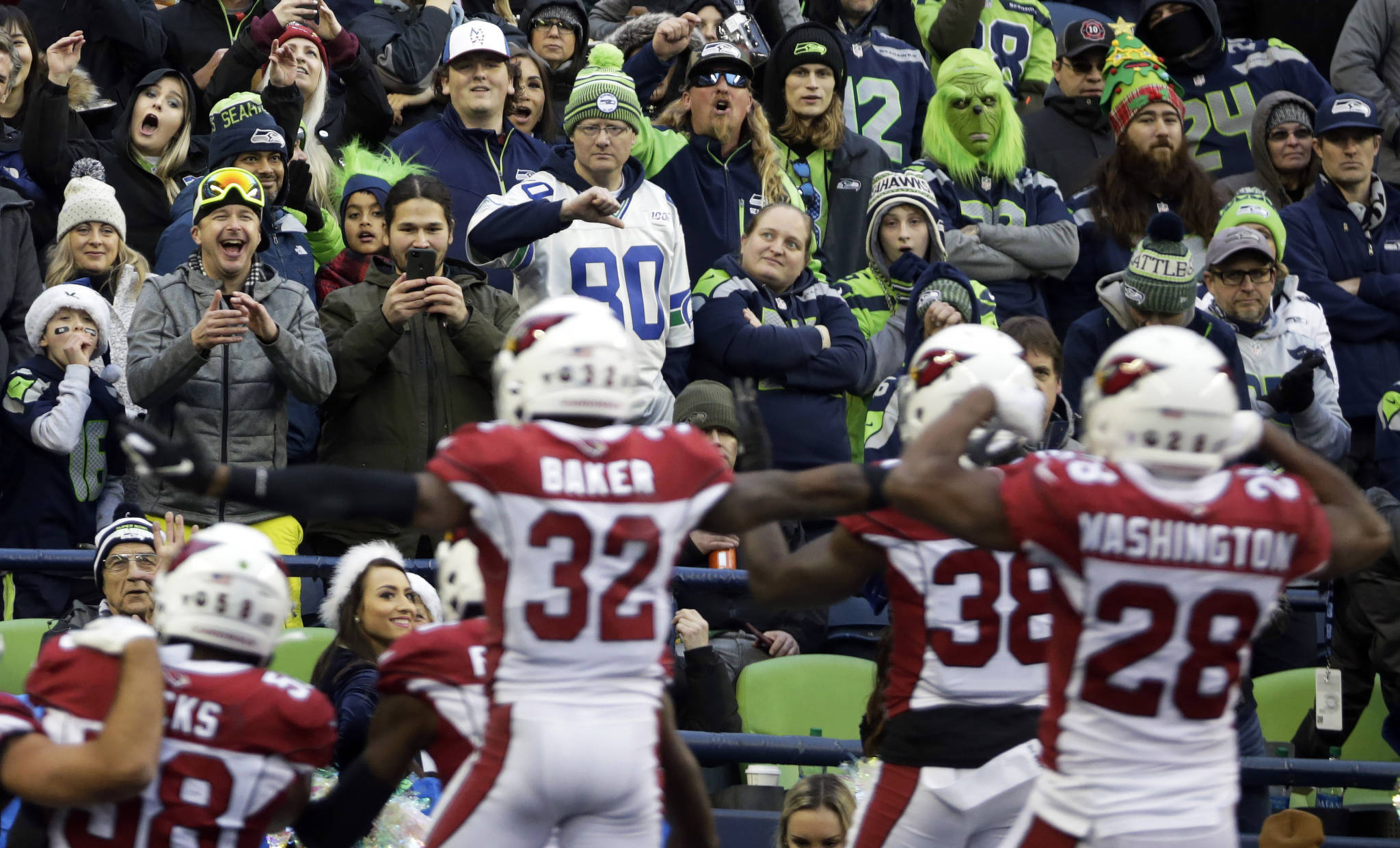 Seattle Seahawks fans react as the Arizona Cardinals celebrate a fumble recovery by middle linebacker Jordan Hicks (lower left) in the second half of Sunday’s game in Seattle. (AP Photo/Lindsey Wasson)