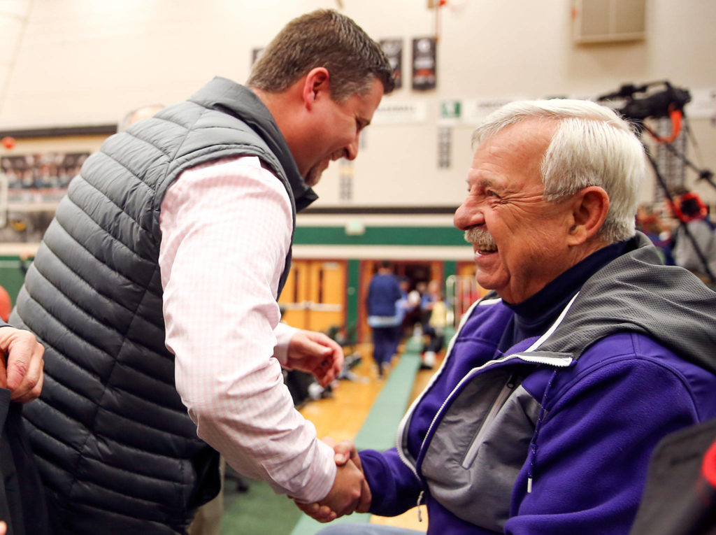 Basketball official Mark Myers (left) shares a laugh with his father, Dennis, also a longtime area official, before a Dec. 13 game at Jackson High School in Mill Creek. (Kevin Clark / The Herald)
