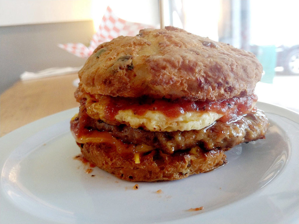 The Lumberjack sandwich at Biscuit & Bean in Lake Stevens is made with a sausage patty, egg, cheddar and tomato jam on either a buttermilk or cheddar onion biscuit. (Sara Bruestle / The Herald)
