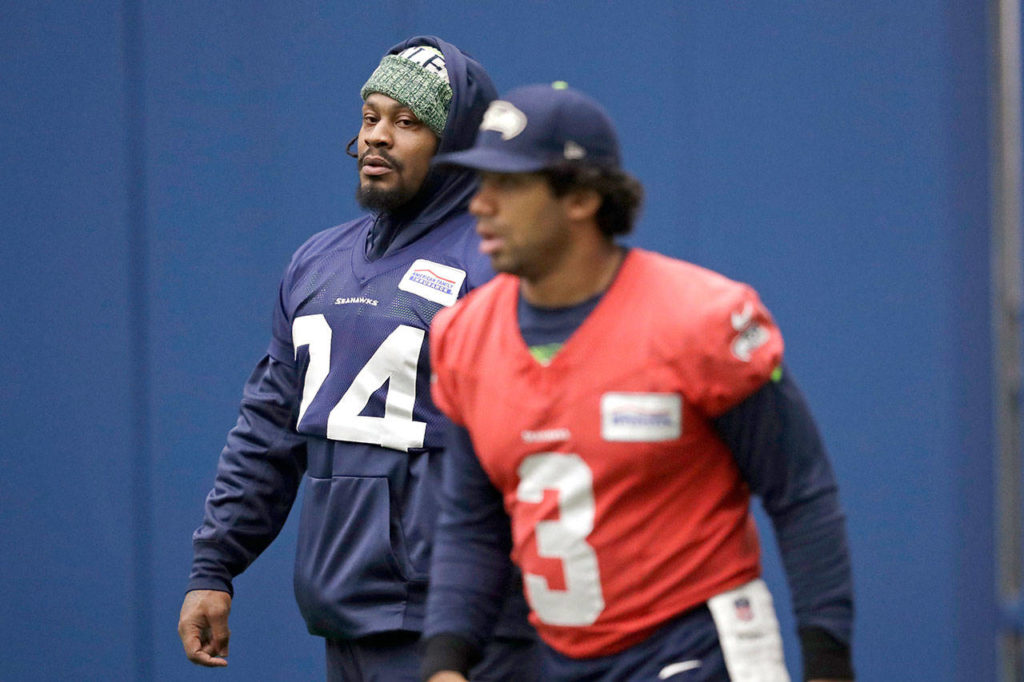 Seattle running back Marshawn Lynch (left) looks across at Seahawks quarterback Russell Wilson during the teams practice Tuesday in Renton. (AP Photo/Elaine Thompson)
