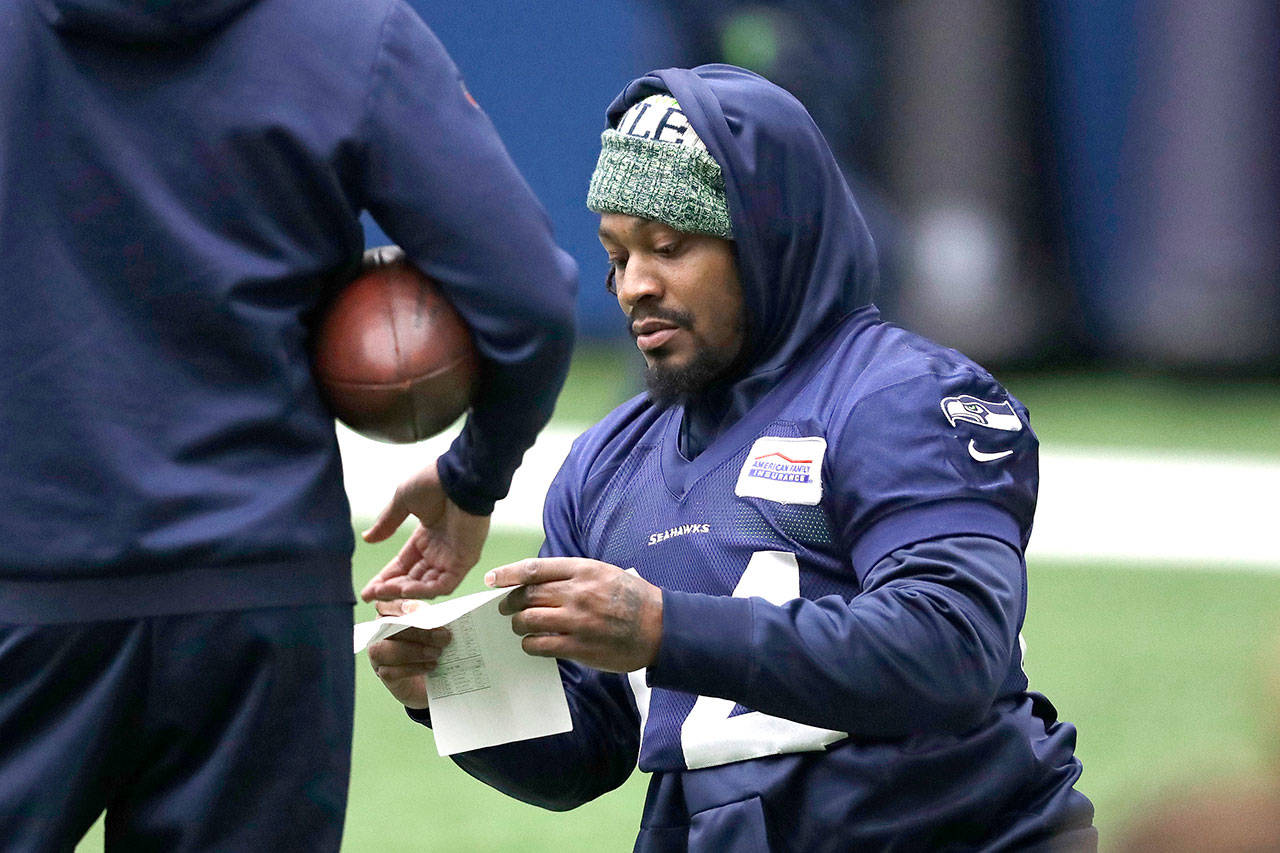 Seattles Marshawn Lynch looks over notes during a workout at the teams practice facility on Dec. 24 in Renton. (AP Photo/Elaine Thompson)