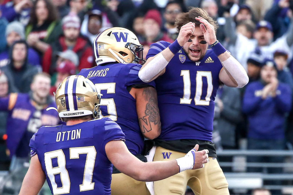 Washington Huskies quarterback Jacob Eason (10) celebrates his touchdown with offensive lineman Nick Harris (56) and tight end Cade Otton (87) during the 112th Apple Cup at Husky Stadium on Nov. 29. The Huskies won 31-13. (Kevin Clark / Herald file)
