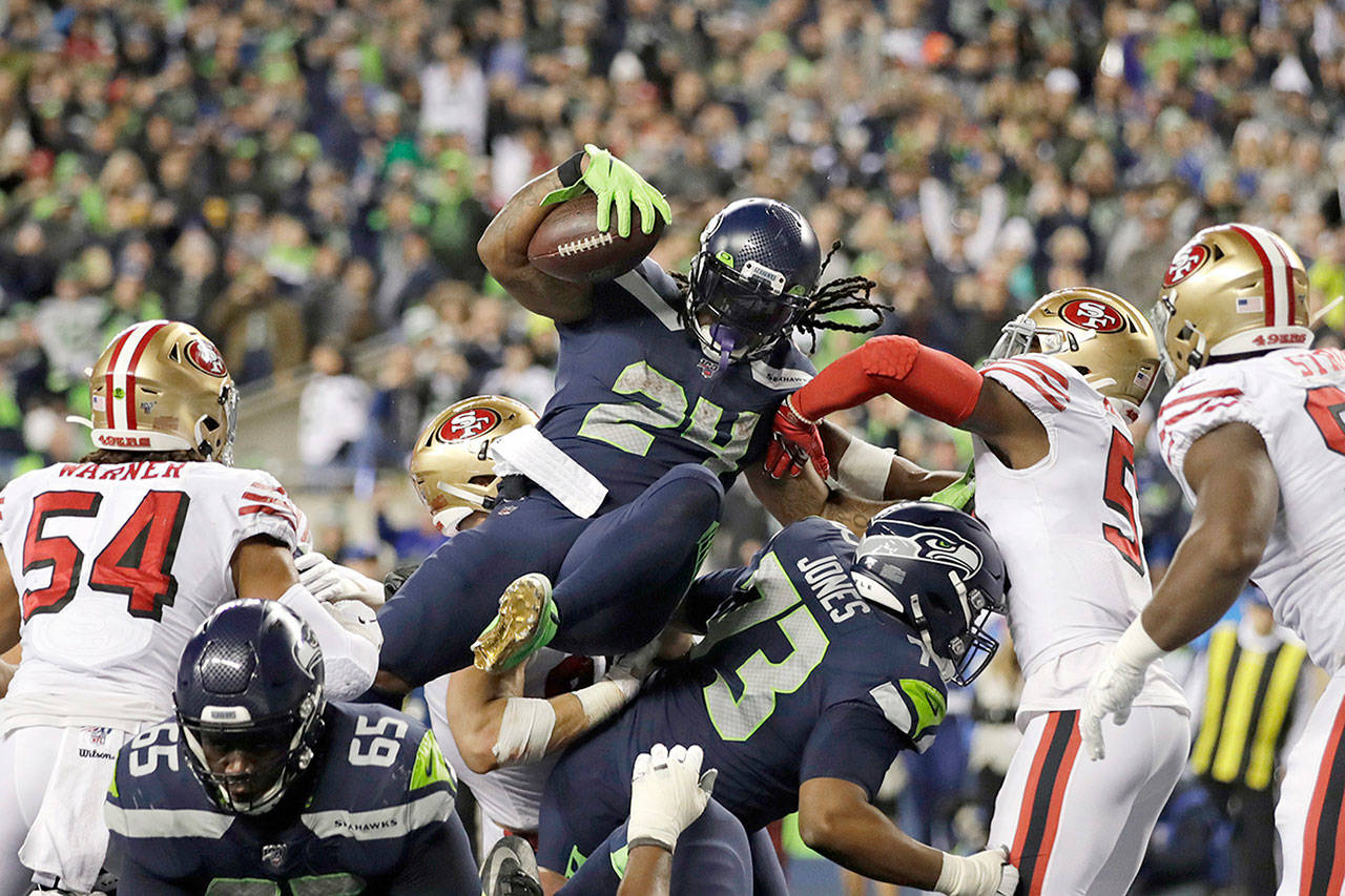 Seahawks running back Marshawn Lynch (24) scores a touchdown on a 1-yard run during the second half of Sunday’s game in Seattle. (AP Photo/Stephen Brashear)