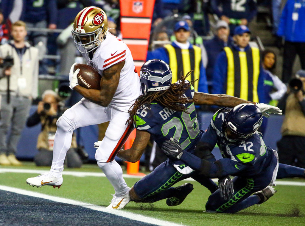 San Francisco’s Raheem Mostert scores a touchdown past Seahawks defense Sunday evening at CenturyLink Field in Seattle on December 29, 2019. The 49ers won 26-21. (Kevin Clark / The Herald)
