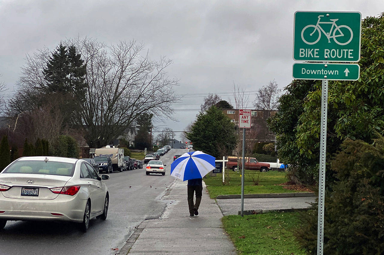 A man walks in the rain along Hoyt Ave. in Everett on Tuesday afternoon. (Sue Misao / The Herald)