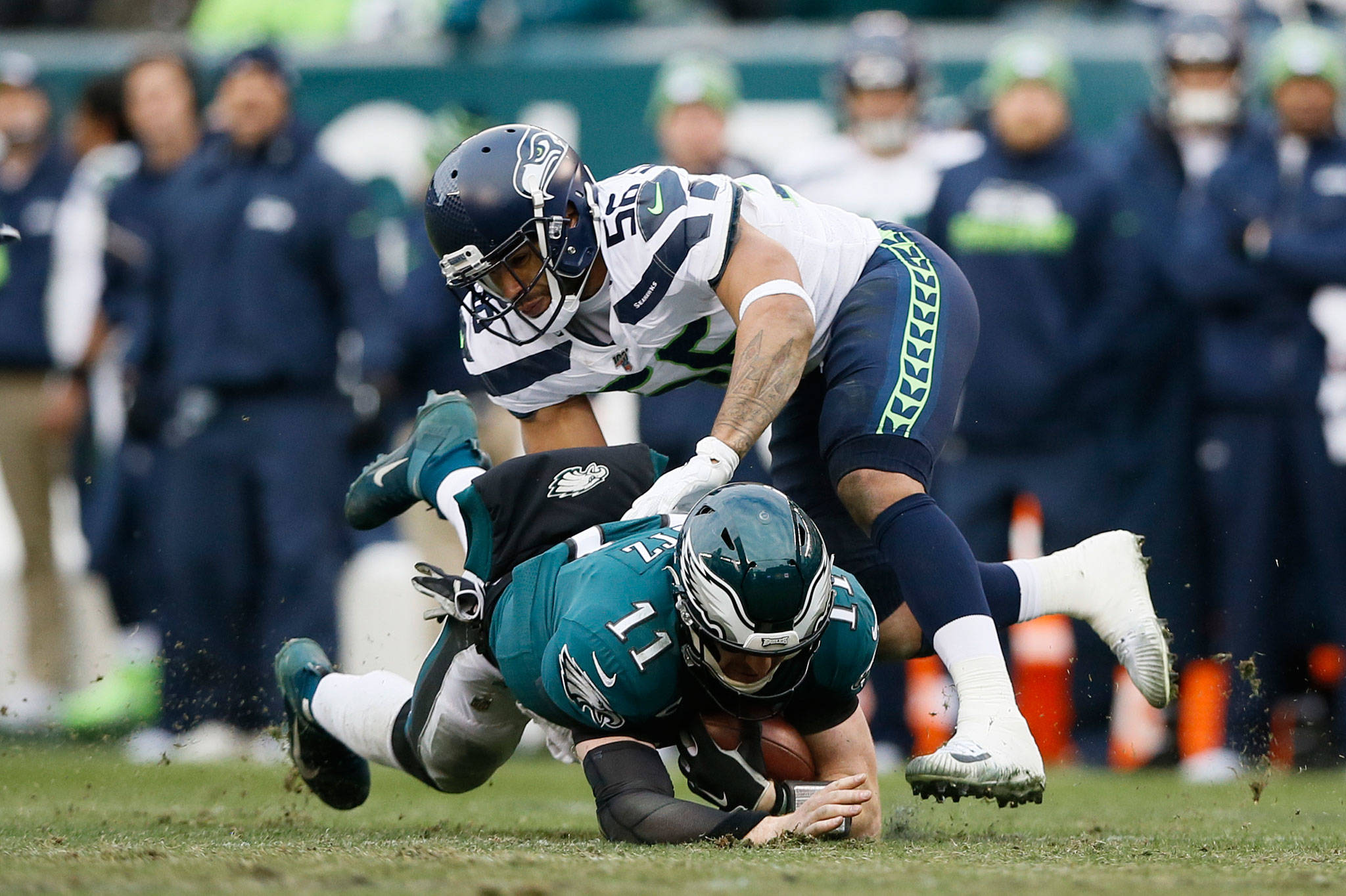 The Eagles’ Carson Wentz (11) is tackled by the Seahawks’ Mychal Kendricks (56) during the second half of a game Nov. 24, 2019, in Philadelphia. (AP Photo/Michael Perez)