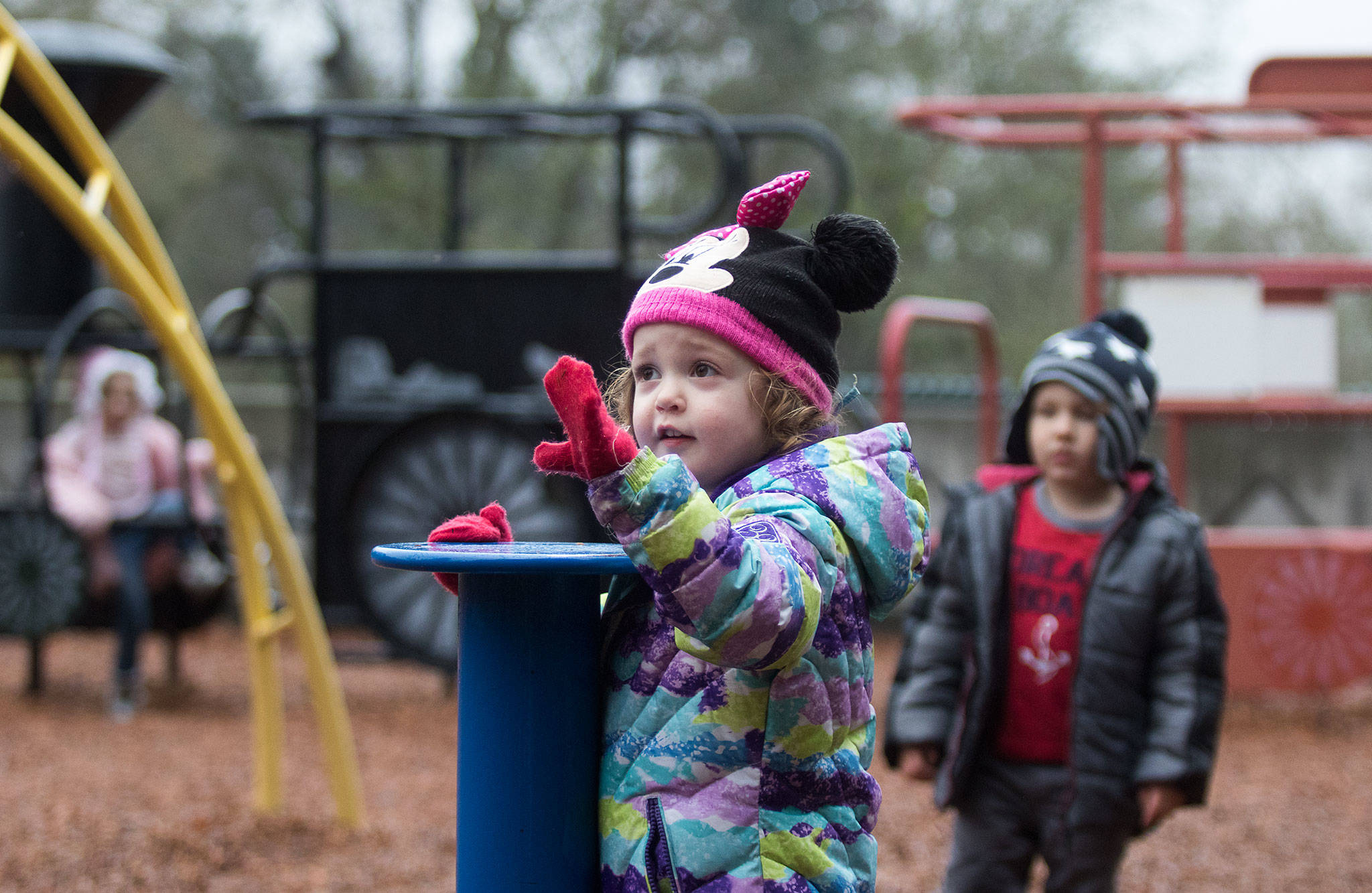Alison Estes, 3, asks for five more minutes on a spinner at the playground with friends Monday at Forest Park in Everett. The playground is set for a complete overhaul and should be ready in spring 2020. (Andy Bronson / The Herald)