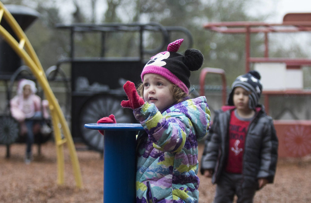 Alison Estes, 3, asks for five more minutes on a spinner at the playground with friends Monday at Forest Park in Everett. The playground is set for a complete overhaul and should be ready in spring 2020. (Andy Bronson / The Herald)
