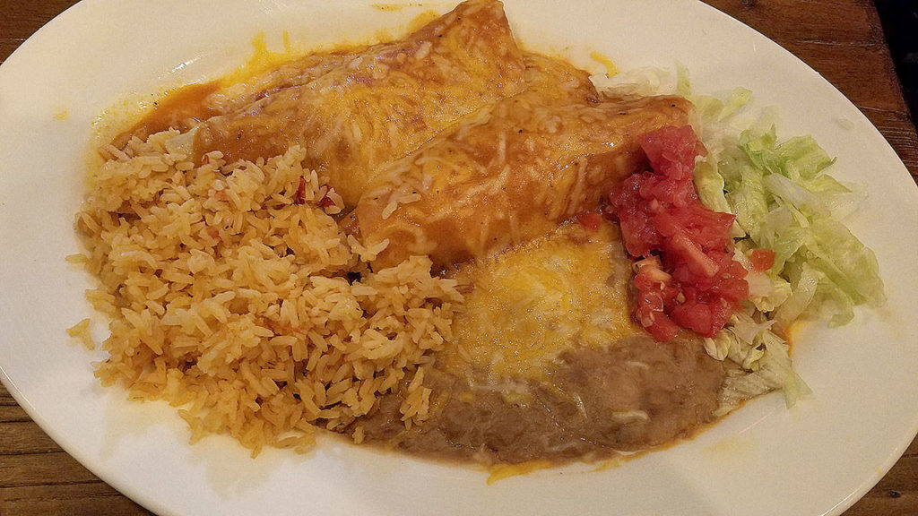 Santa Fe Mexican Grill’s plate of chicken enchiladas is served with the customary side of rice and beans. (Sharon Salyer / The Herald)
