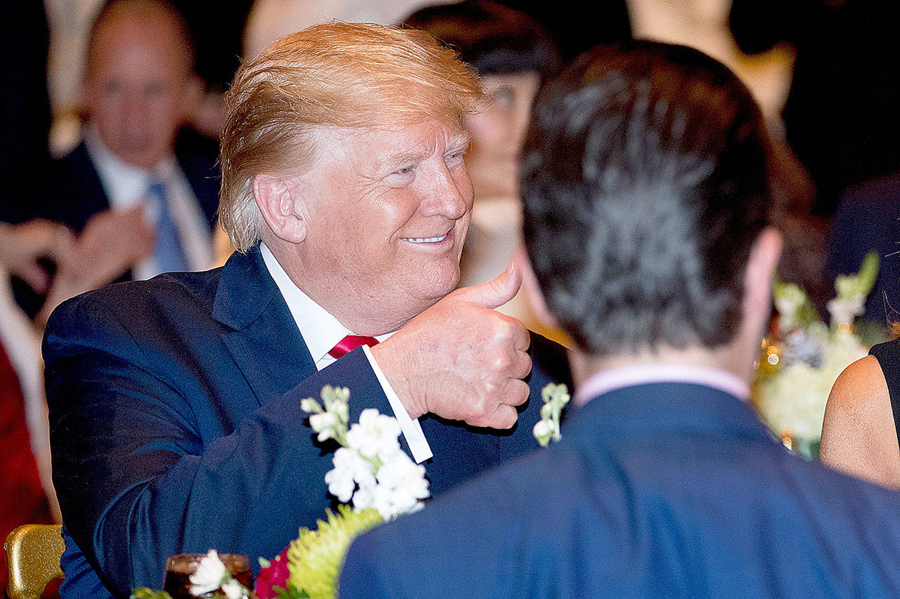 President Donald Trump gives a thumbs-up after arriving for Christmas Eve dinner at Mar-a-lago in Palm Beach, Fla., Christmas Eve. (AP Photo/Andrew Harnik)