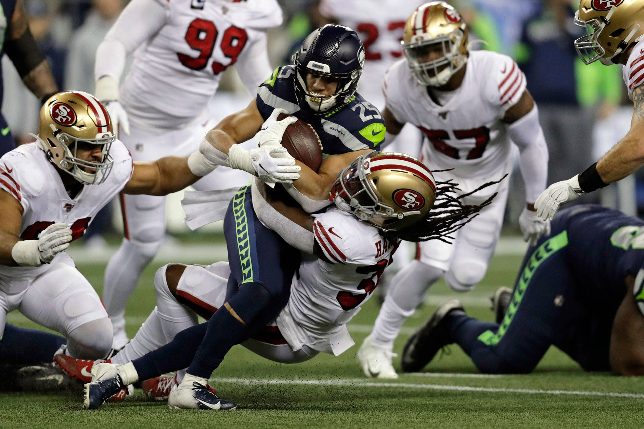 Seahawks running back Travis Homer (25) is brought down by the 49ers’ Marcell Harris on a carry during the first half of a game this past Sunday in Seattle. (AP Photo/Stephen Brashear)