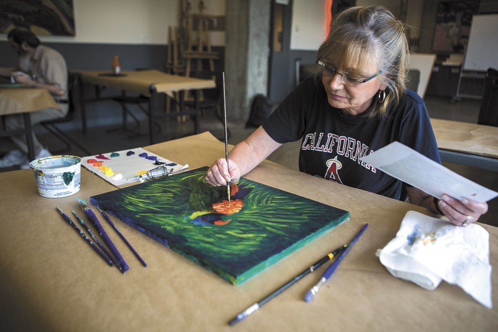 Brenda Sharkey works on a painting during Pete Barth’s class at the Schack Art Center in Everett. (Olivia Vanni / The Herald)
