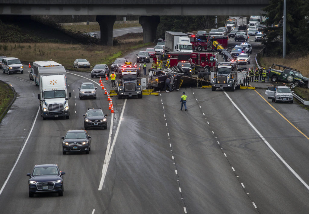 I-5 bound traffic from I-405 and northbound I-5 traffic merge together into one lane as firefighters and police work to clear a flipped semi blocking all northbound I-5 lanes on Thursday in Lynnwood. (Olivia Vanni / The Herald).
