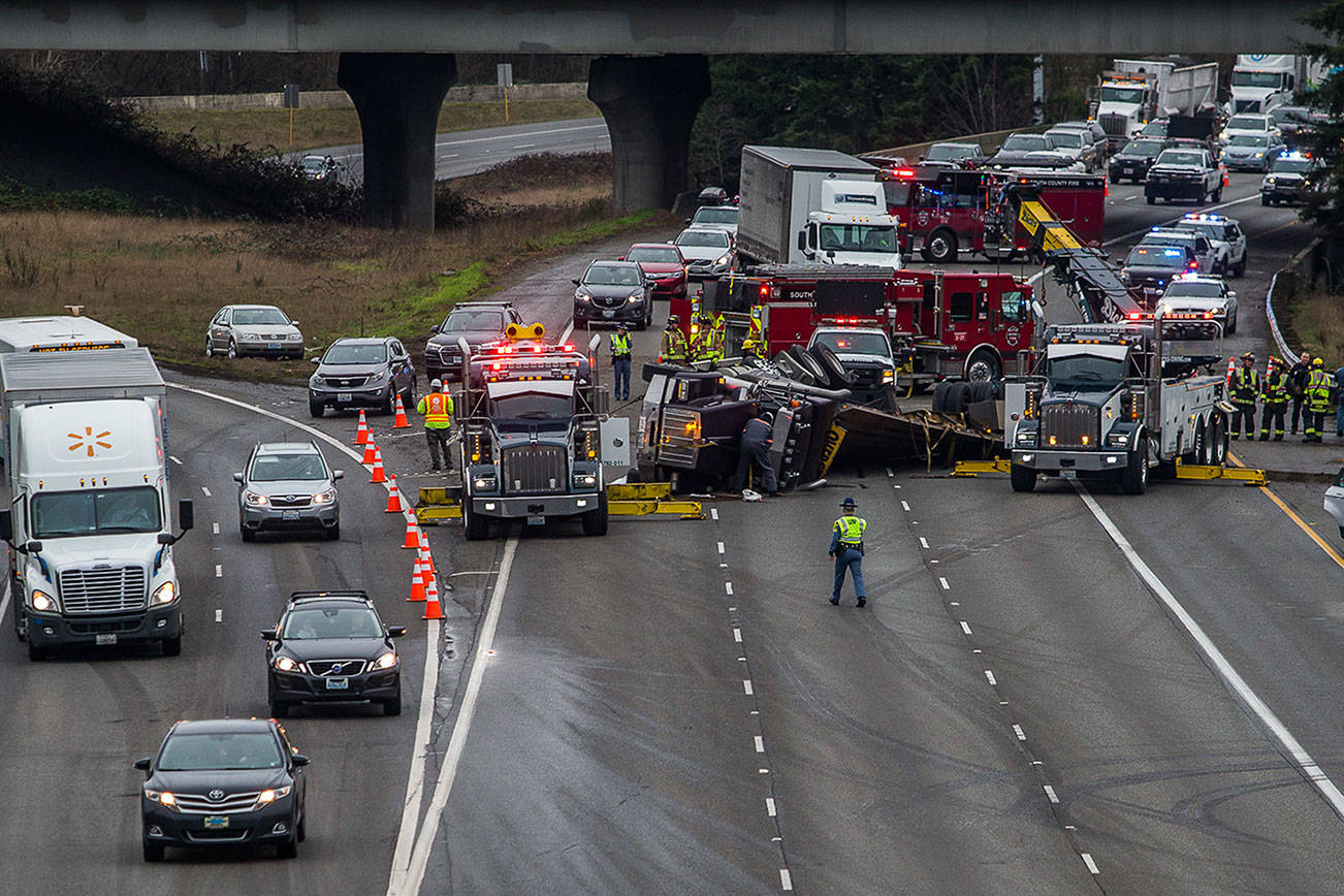 I-5 bound traffic from I-405 and northbound I-5 traffic merge into one lane as firefighters and police work to clear a flipped semi blocking all northbound I-5 lanes Thursday in Lynnwood. (Olivia Vanni / The Herald)