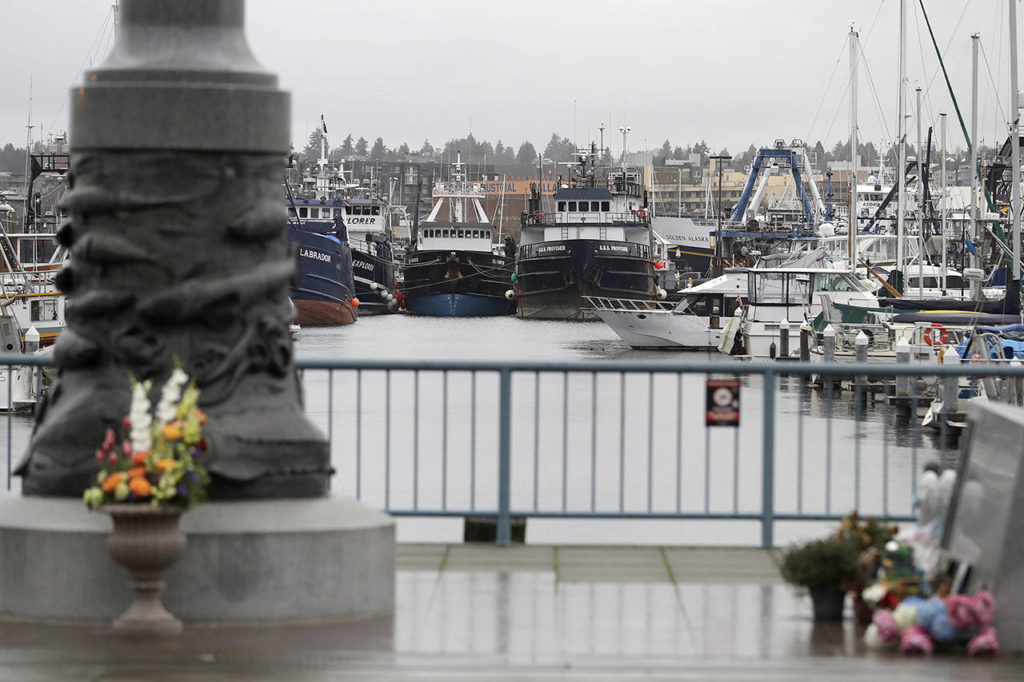 Fishing boats and other vessels parked near the Seattle Fishermen’s Memorial on Thursday in Seattle. Items left at the memorial included a ball cap with the name of the crab fishing boat Scandies Rose, which sank on New Year’s Eve. (AP Photo/Ted S. Warren) 
