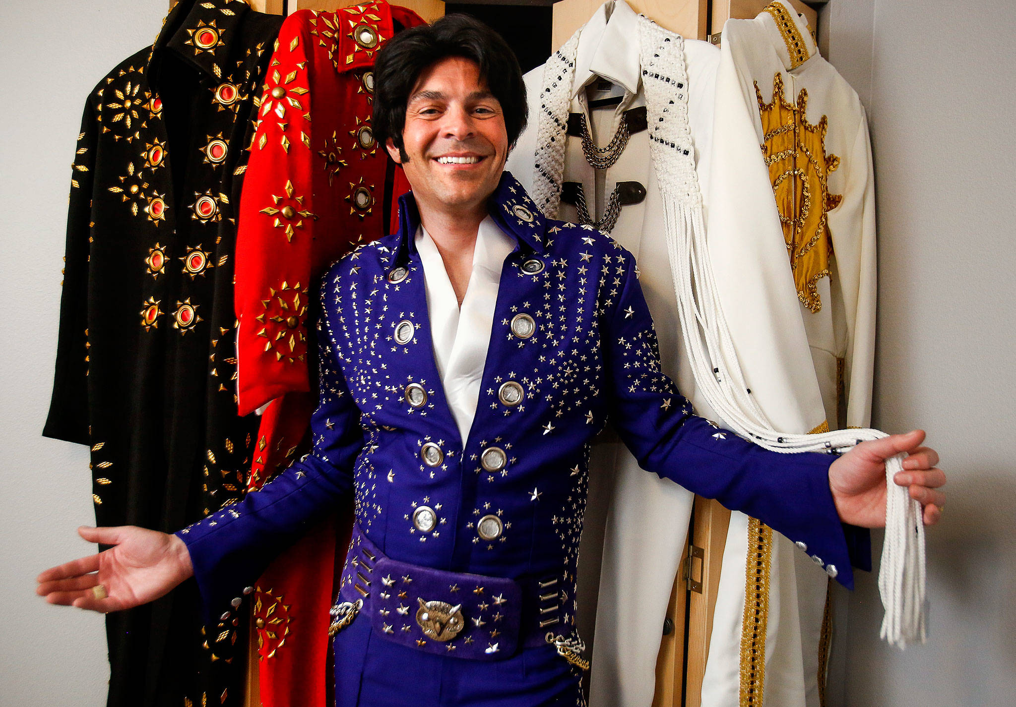 Everett’s Rob Schwertley has a collection of Elvis jumpsuits that he wears when he performs as tribute artist Robbie Dee. The white and gold outfit at right was made by his mother, Paulette Schwertley. (Dan Bates / The Herald)
