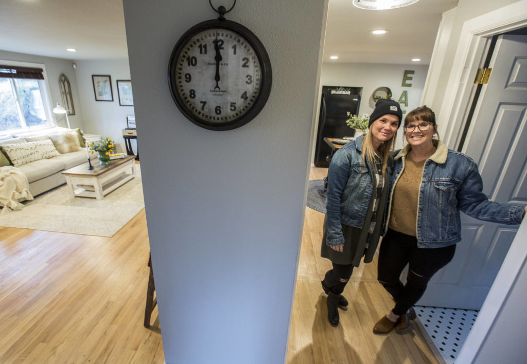 Snohomish twin sisters Lyndsay Lamb, right, and Leslie Davis pose inside one of their local remodeled homes that will be on their new HGTV series “Unsellable Houses,” which starts Feb. 4. This home in Everett went on the market last week. (Olivia Vanni / The Herald)
