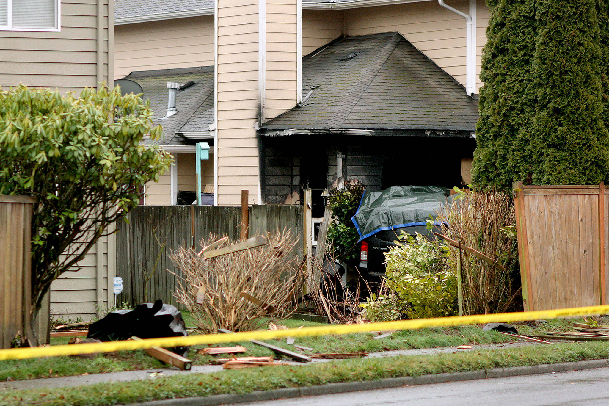 A car crashed through a power pole and into a house in Mountlake Terrace on Monday. A person in the car died, and the accident started a fire at the home. (Zachariah Bryan / The Herald)