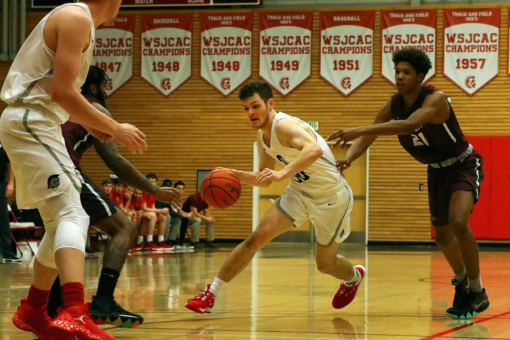 Everett Community College’s Bobby Martin dribbles into the lane with Pierce’s Elijah Glenn trailing during a Jan. 2 game at the Walt Price Student Fitness Center in Everett. (Kevin Clark / The Herald)
