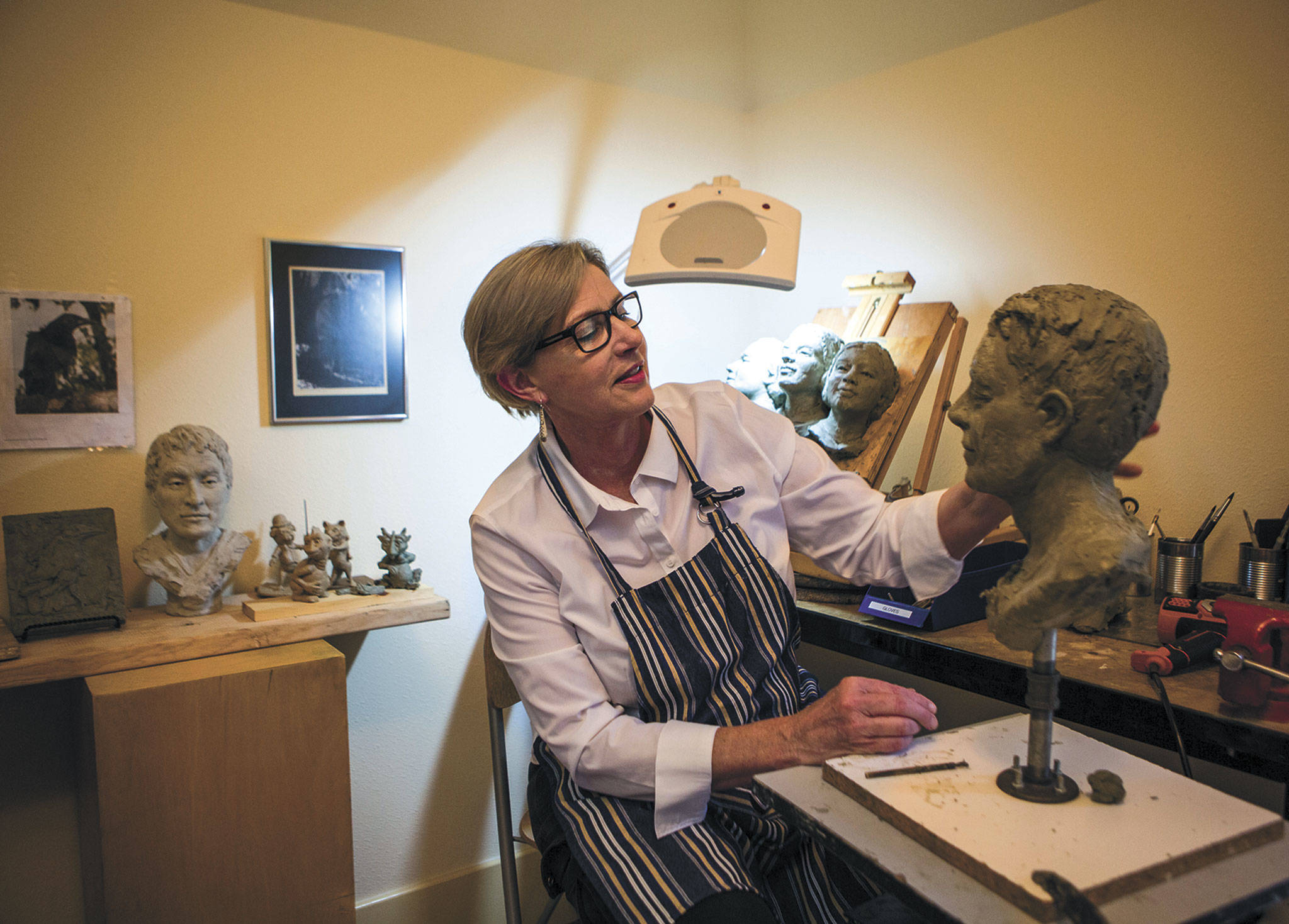 Judeth Davis works on a bust at her studio in Granite Falls. (Olivia Vanni / The Herald)
