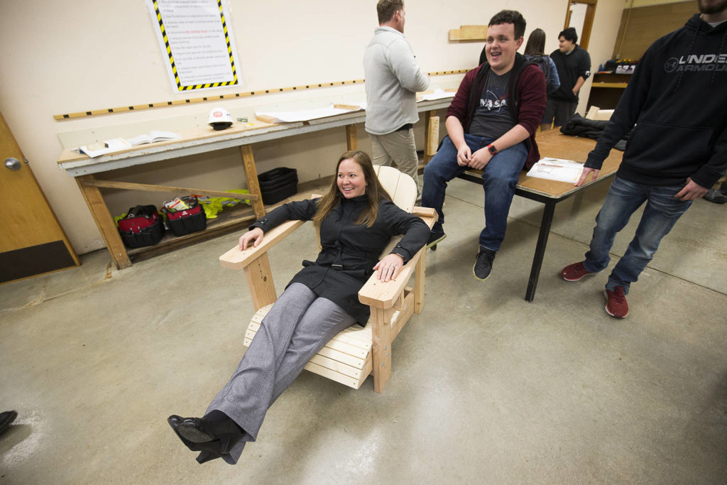 Rochelle Lubbers, the Tulalip Tribes ambassador to the Marysville School District Board of Directors, sits in a chair made by students in the Regional Apprenticeship Pathways Program at Marysville Pilchuck High School. (Andy Bronson / The Herald)
